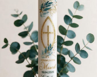 May include: A white cylindrical candle featuring a gold glitter cross inside an almond-shaped outline. The design includes blue and green watercolor leaves with gold accents. Text reads KOMMUNION, Marcel, 19.04.2026, and Gott ist mein Licht.
