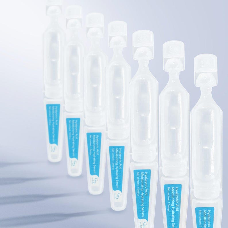 May include: A row of clear, plastic ampoules with white caps and blue labels. Each ampoule contains a moisturizing serum with the text "Hyaluronic Acid Moisturizing Hydrating Serum". The background is a gradient of white to light blue.