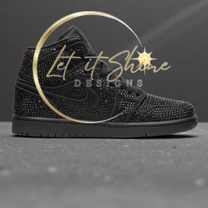 May include: Black high-top sneaker covered in small, sparkling embellishments. The shoe features a classic design with a Nike swoosh and a solid black sole. The text "Let it Shine DESIGNS" is displayed in gold.