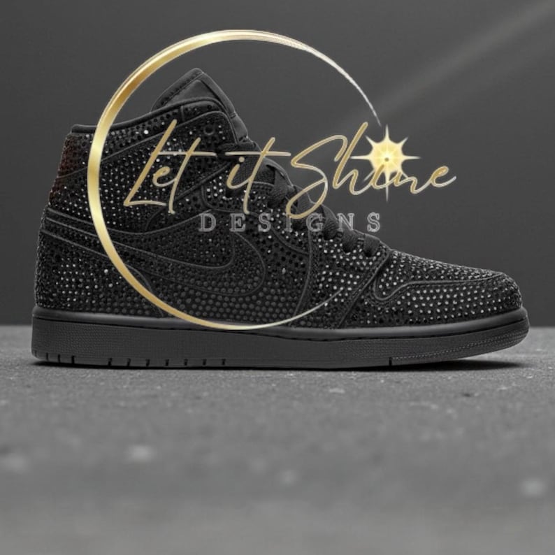 May include: Black high-top sneaker covered in small, sparkling embellishments. The shoe features a classic design with a Nike swoosh and a solid black sole. The text "Let it Shine DESIGNS" is displayed in gold.