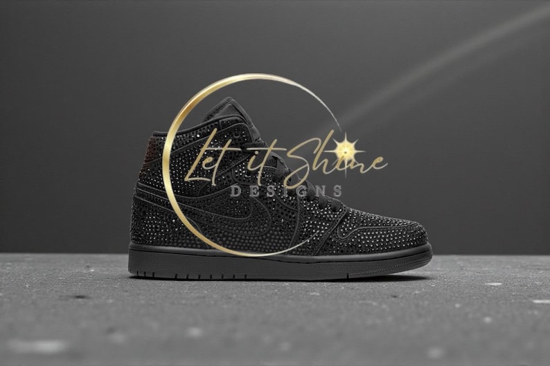 May include: Black high-top sneaker embellished with sparkling accents. The shoe features a classic design with a prominent Nike swoosh and the text "Let It Shine Designs" in gold.