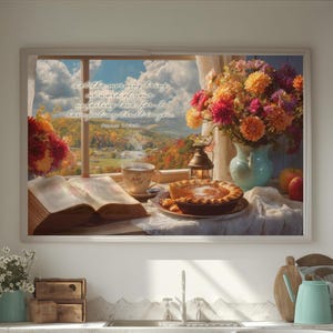 May include: A cozy kitchen scene with a framed artwork depicting a window view of a landscape, a pie, and flowers. A red and white checkered tablecloth covers a table with a tray of fruit. White cabinets and a window frame the scene.