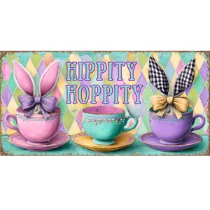 May include: A decorative sign featuring three teacups with bunny ears and bows. The teacups are pink, teal, and purple, with matching saucers. The sign has the words "HIPPITY HOPPITY" in purple and teal lettering, set against a colorful diamond pattern.
