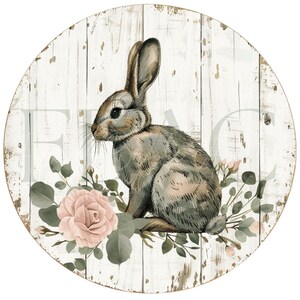 May include: Round wooden sign with a distressed white background and a watercolor illustration of a rabbit, pink roses, and greenery. The sign has a rustic, farmhouse aesthetic.