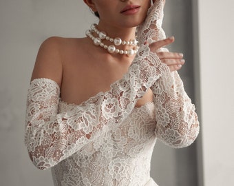 Jennifer: Exquisite open lace mermaid wedding gown, adorned with delicate lace sleeves. Elevate your bridal elegance!