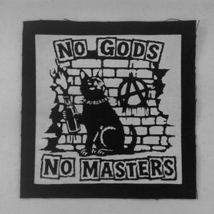 May include: A square black and white fabric patch featuring a graphic of a cat holding a flaming bottle in front of a brick wall. The text NO GODS is printed above the cat and NO MASTERS is printed below. An anarchy symbol is visible on the wall.