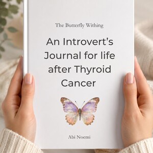 Puede incluir: Un diario de tapa dura blanco titulado The Butterfly Withing: An Introvert's Journal for life after Thyroid Cancer de Abi Noemi. La portada presenta una mariposa estilo acuarela con alas moradas, rosas y naranjas centrada debajo del texto.