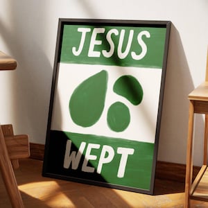 May include: A framed print with the text "JESUS WEPT" in white letters on a green background. The top half of the print is white with green abstract shapes.