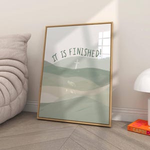 May include: A framed print with a green and white abstract landscape design. The text "IT IS FINISHED!" is written in a curved line across the top of the image. A white cross is visible in the center of the image.