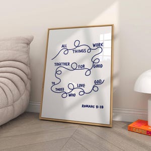 May include: A framed print with the words "ALL THINGS WORK TOGETHER FOR GOOD TO THOSE WHO LOVE GOD" in navy blue script. The text is arranged in a looping design on a white background. The bottom of the print reads "ROMANS 8:28".