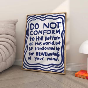 May include: A framed print with a blue and white wavy background. The text on the print reads "DO NOT CONFORM to the pattern of this world, but be transformed by the RENEWING of your mind. ROMANS 12:2."