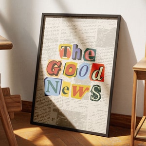 May include: A framed print with a newspaper background and the words "The Good News" in colorful, cut-out letters.