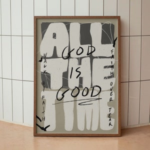 May include: A framed print with a beige background and black text that reads "All the time God is good." The text is styled with a bold, handwritten font and is surrounded by a black and grey web-like design. The words "Walk by faith" and "Faith over fear" are written vertically on the left and right sides of the print.