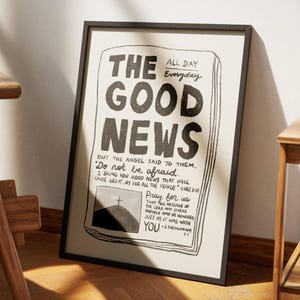 Może przedstawiać: Czarno-biały wydruk nagłówka gazety z napisem "The Good News" z krzyżem na wzgórzu i wersetami biblijnymi. Wydruk jest oprawiony w czarną ramę.