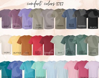 May include: Color chart showing 24 different colors of t-shirts from the Comfort Colors 1717 line. The colors are arranged in rows and include names like Wine, Berry, Violet, Sand Stone, Gray, Khaki, Blue Jean, Pepper, Black, Ivory, Butter, Yam, Water Melon, Crimson, Bay, Blue Spruce, Light Green, Moss, Topaz Blue, Flow Blue, Lagoon, Chaulky Mint, Hydrangea, Chambray, Blossom, Crunch Berry, and Orchid.