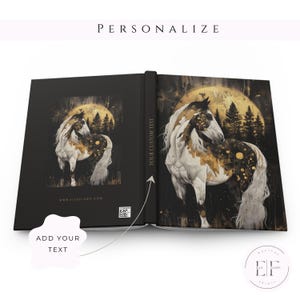 May include: A black and gold personalized journal with a white horse standing in a forest with a full moon in the background. The journal has the text "Your Custom Text" on the spine and the website "www.elfeflows.com" on the front cover.