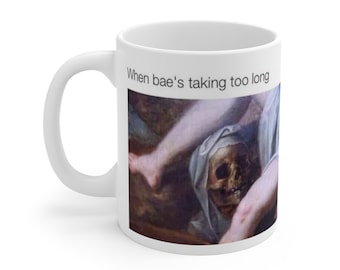 Può includere: Tazza in ceramica bianca con testo nero sovrapposto che recita "When bae's taking too long". La tazza presenta un dipinto di una gamba di donna e un teschio con un cappuccio bianco.