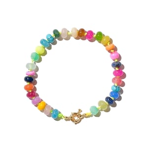 May include: A colorful beaded bracelet with a rainbow of colors, including pink, blue, green, yellow, orange, and red. The bracelet has a gold clasp.