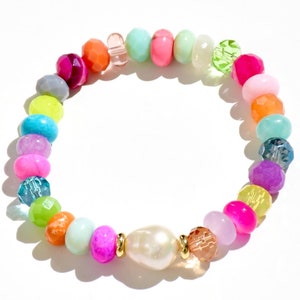 May include: A colorful beaded bracelet featuring a large, off-white pearl and an array of vibrant beads in shades of pink, orange, green, blue, and purple. The bracelet is made with small, round beads and a central pearl, creating a playful and eye-catching accessory.