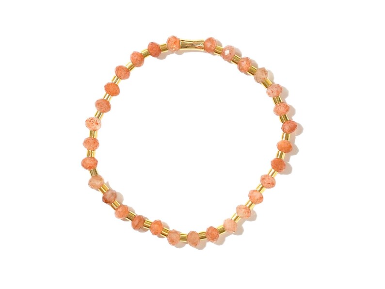 May include: A gold bracelet with small, orange-colored beads. The bracelet is made of metal and has a simple design.