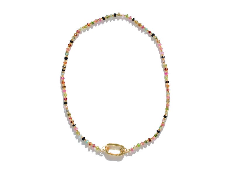 May include: A colorful beaded necklace with a gold clasp. The beads are small and varied in color, including pink, green, blue, and black.