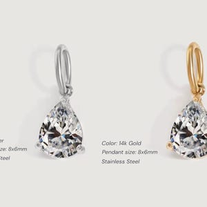 Gold diamond crystal charm displayed on a white background, each featuring a pear cut The clear faceted stones shimmer in the light, framed in gold settings with looped bails for attaching to necklaces or bracelets. Elegant minimalist photo showing jewelry-making pendants available in both gold and silver options.  Perfect for diy jewelry to use as add-on charms for any charm necklace or charm bracelet.