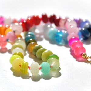 A rainbow multi-gemstone opal necklace that is handknotteded & handcrafted.  Made from natural semi precious opal gemstones.  This necklace is sure to add a pop of color to any outfit. It features a gold dragonfly pendant.