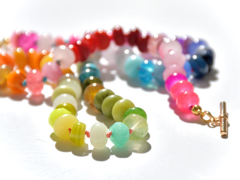 A rainbow multi-gemstone opal necklace that is handknotteded & handcrafted.  Made from natural semi precious opal gemstones.  This necklace is sure to add a pop of color to any outfit. It features a gold dragonfly pendant.