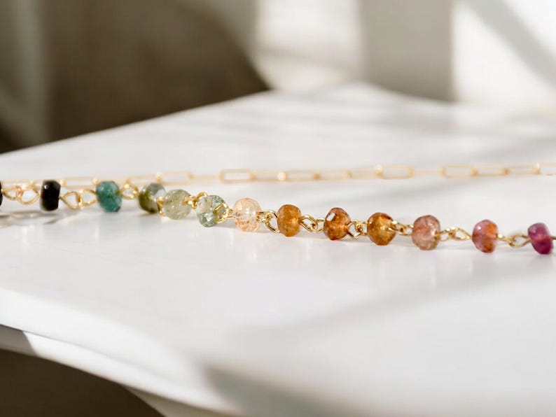 Gorgeous rainbow tourmaline rondelle beaded necklace that is wire wrapped toa 14k gold filled paperclip chain.  Handmade and handcrafted natural gems