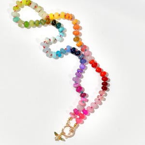 A rainbow multi-gemstone opal necklace that is handknotteded & handcrafted.  Made from natural semi precious opal gemstones.  This necklace is sure to add a pop of color to any outfit. It features a gold dragonfly pendant.