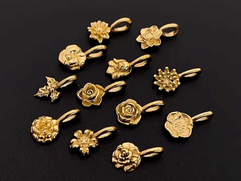 Gold birth flower charm representing each month, featuring a delicate embossed floral design on a round gold pendant — a personalized jewelry gift for her.
