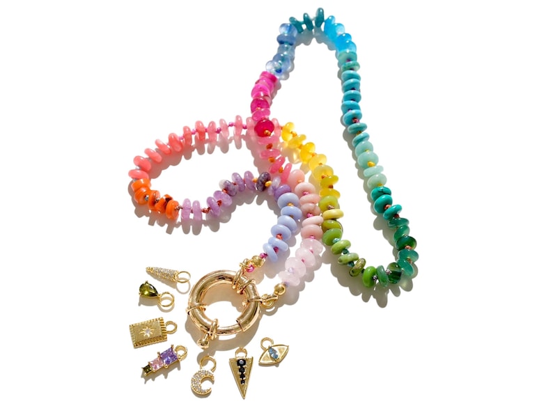 May include: A rainbow colored beaded necklace with a gold clasp and several charms, including a crescent moon, a star, a triangle, and an evil eye.