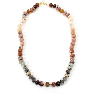A long necklace made of various colored stones. The stones are round and have a natural, polished finish. The necklace is made of a gradient of colors, starting with light brown and transitioning to dark gray. The necklace is strung on a gold chain.