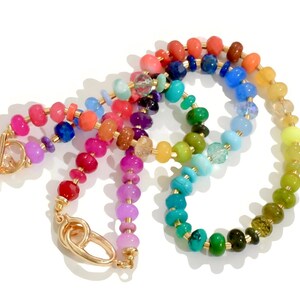 Colorful rainbow gemstone necklace and bracelet set featuring faceted natural stones in bold, vibrant hues with gold accents and a toggle clasp. Handmade statement jewelry displayed on a vanity with soft lighting, highlighting the sparkle and rich texture of each bead. Perfect for stacking or wearing solo.