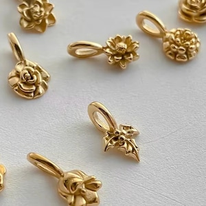 Gold birth flower charm representing each month, featuring a delicate embossed floral design on a round gold pendant — a personalized jewelry gift for her.