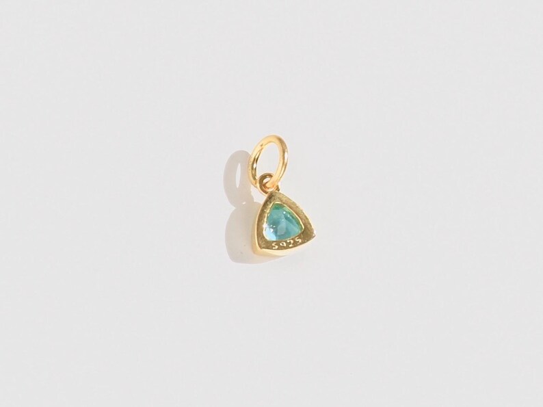 14k gold vermeil birthstone charms in a triangular bezel setting, each featuring a different colored gemstone, arranged neatly on a white background. Designed for necklaces and bracelets.