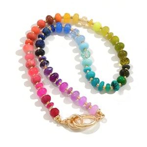Colorful rainbow gemstone necklace featuring faceted natural stones in bold, vibrant hues with gold accents and a toggle clasp. Handmade statement jewelry displayed on a vanity with soft lighting, highlighting the sparkle and rich texture of each bead. Perfect for stacking or wearing solo.