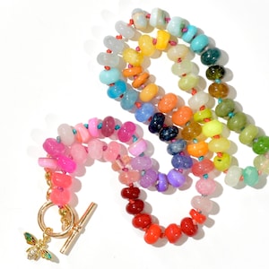 A rainbow multi-gemstone opal necklace that is handknotteded & handcrafted.  Made from natural semi precious opal gemstones.  This necklace is sure to add a pop of color to any outfit. It features a gold dragonfly pendant.