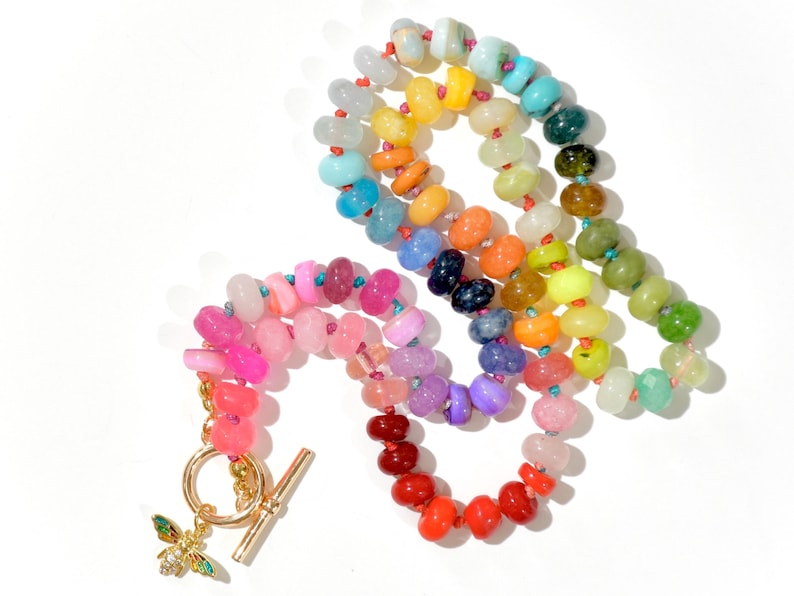 A rainbow multi-gemstone opal necklace that is handknotteded & handcrafted.  Made from natural semi precious opal gemstones.  This necklace is sure to add a pop of color to any outfit. It features a gold dragonfly pendant.