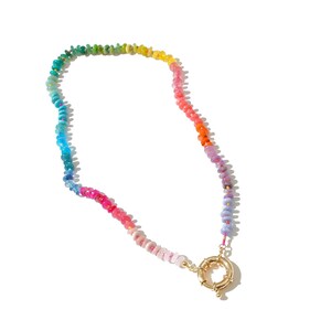 May include: A rainbow-colored beaded necklace with a gold clasp. The beads are small and round, and they are arranged in a gradient from green to purple.
