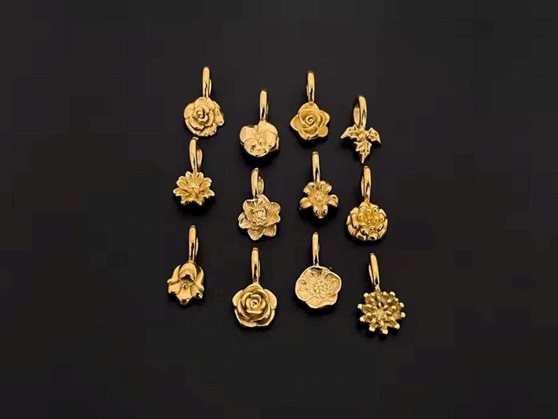 Gold birth flower charm representing each month, featuring a delicate embossed floral design on a round gold pendant — a personalized jewelry gift for her.
