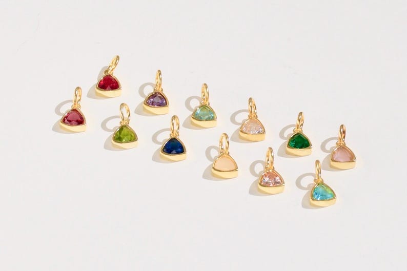 14k gold vermeil birthstone charms in a triangular bezel setting, each featuring a different colored gemstone, arranged neatly on a white background. Designed for necklaces and bracelets.