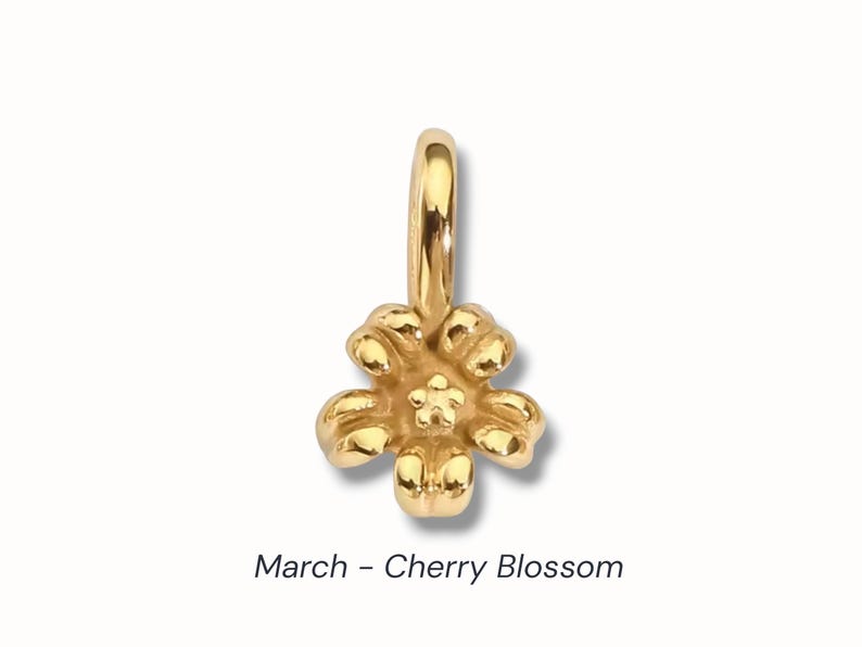 Gold birth flower charm representing each month, featuring a delicate embossed floral design on a round gold pendant — a personalized jewelry gift for her.