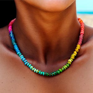 May include: A rainbow colored beaded necklace with small round beads. The necklace is made of a variety of colors, including red, orange, yellow, green, blue, and purple.