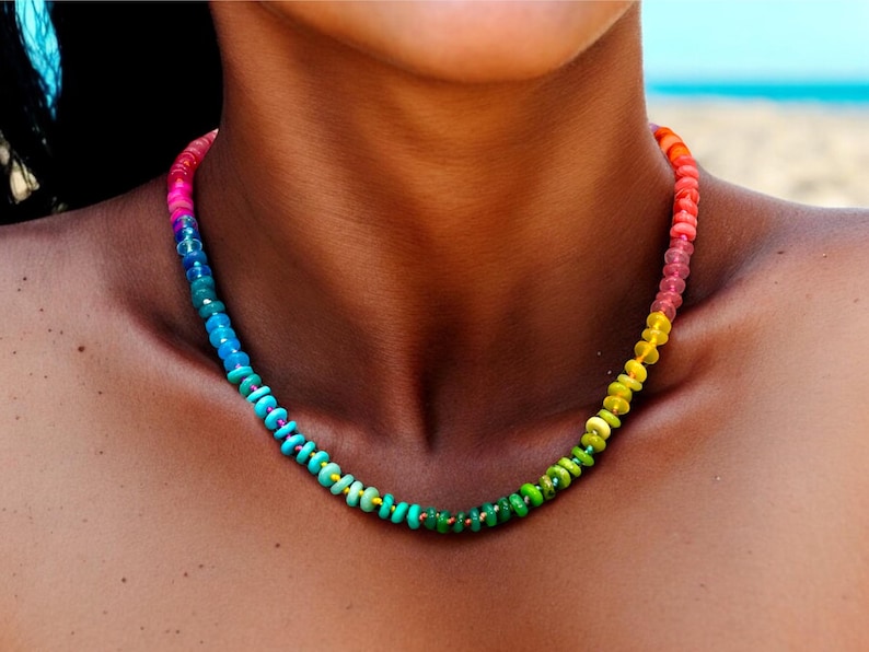 May include: A rainbow colored beaded necklace with small round beads. The necklace is made of a variety of colors, including red, orange, yellow, green, blue, and purple.