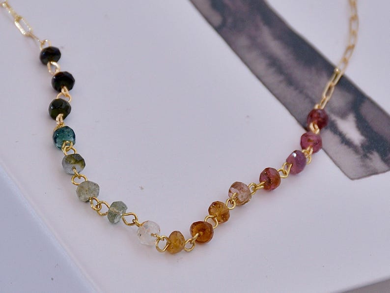 Gorgeous rainbow tourmaline rondelle beaded necklace that is wire wrapped toa 14k gold filled paperclip chain.  Handmade and handcrafted natural gems