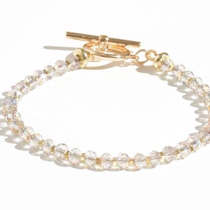 May include: A gold toggle clasp bracelet with clear crystal beads.