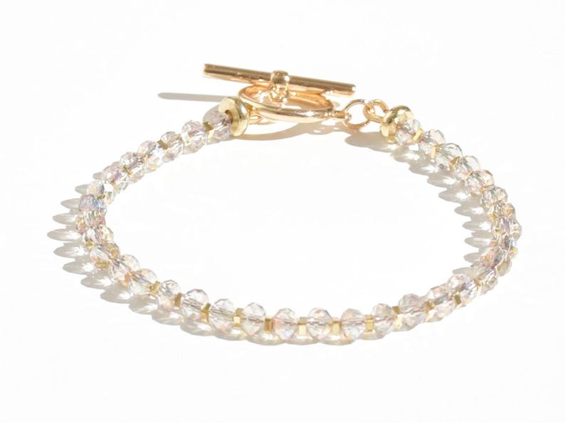May include: A gold toggle clasp bracelet with clear crystal beads.