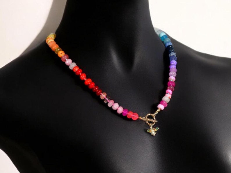 A rainbow multi-gemstone opal necklace that is hand-knotted & handcrafted.  Made from natural semi precious opal gemstones.  This necklace is sure to add a pop of color to any outfit. It features a gold dragonfly pendant.