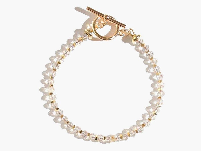 May include: A gold bracelet with a toggle clasp and clear crystal beads.